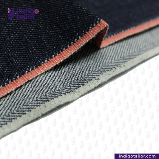 Close-up of DEEP INDIGO TWO COLORED EDGE SELVEDGE DENIM fabric with a visible brand logo on a white background