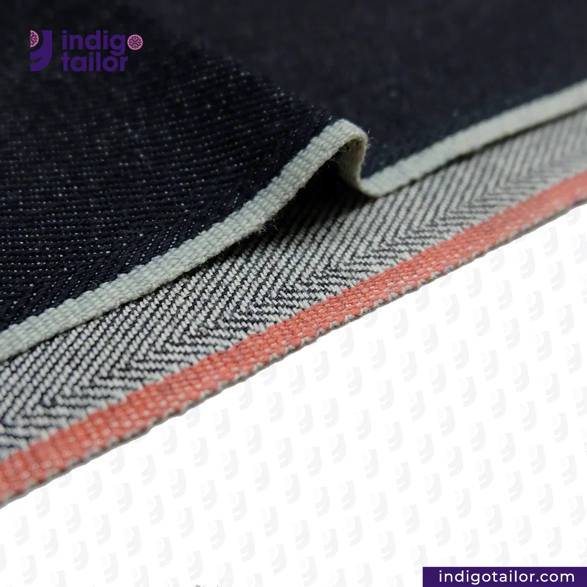 Close-up of DEEP INDIGO TWO COLORED EDGE SELVEDGE DENIM fabric with a herringbone pattern and 'Indigotailor' branding.