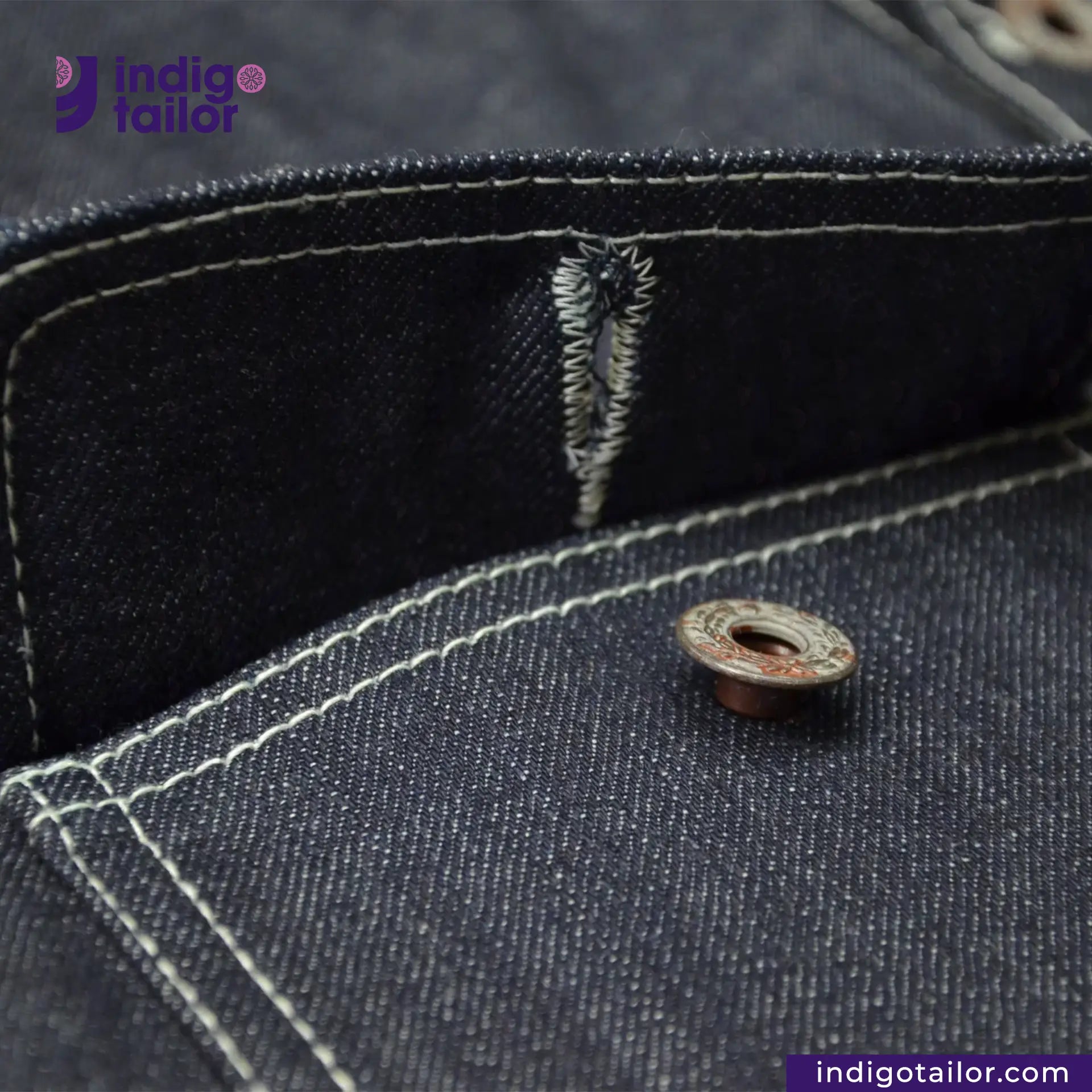 Close-up of a button on a DENIM CHORECOAT shirt with 'Indigotailor' branding.