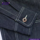 Close-up of a DENIM CHORECOAT shirt pocket with a button, featuring 'Indigotailor' branding.