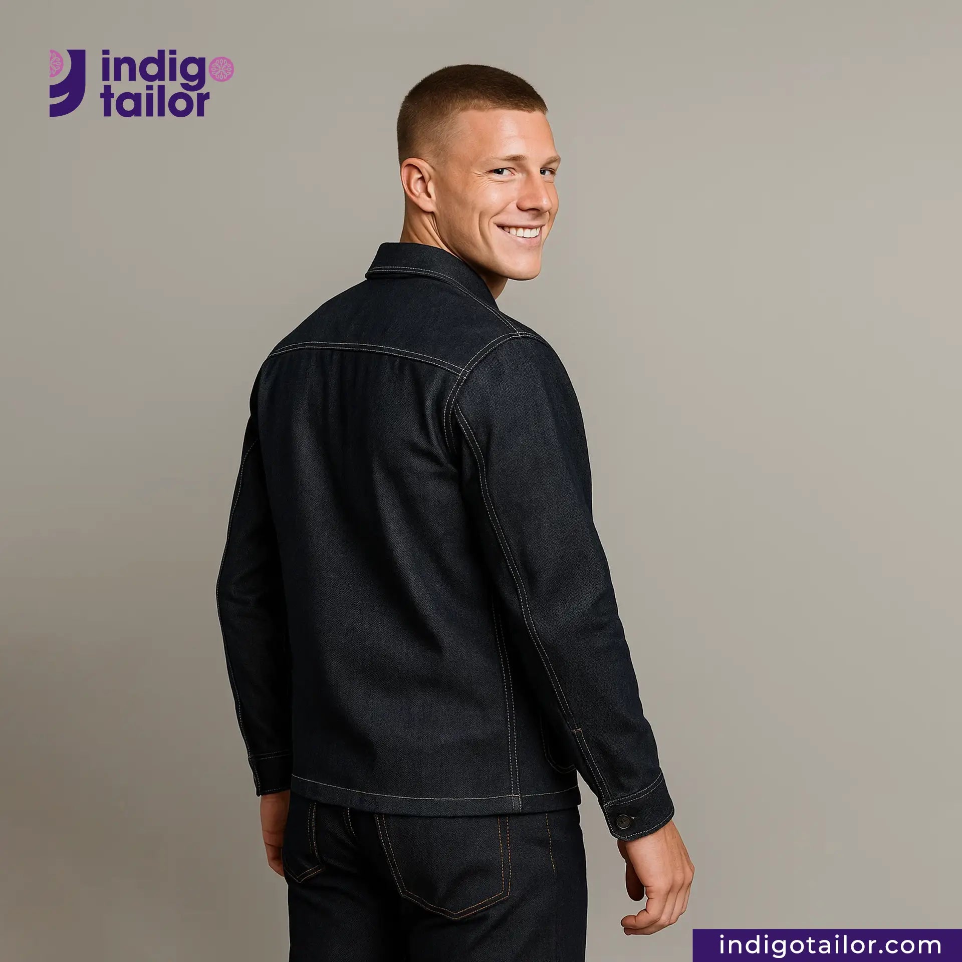Man wearing a DENIM CHORECOAT jacket with 'Indigo Tailor' logo and website on a gray background