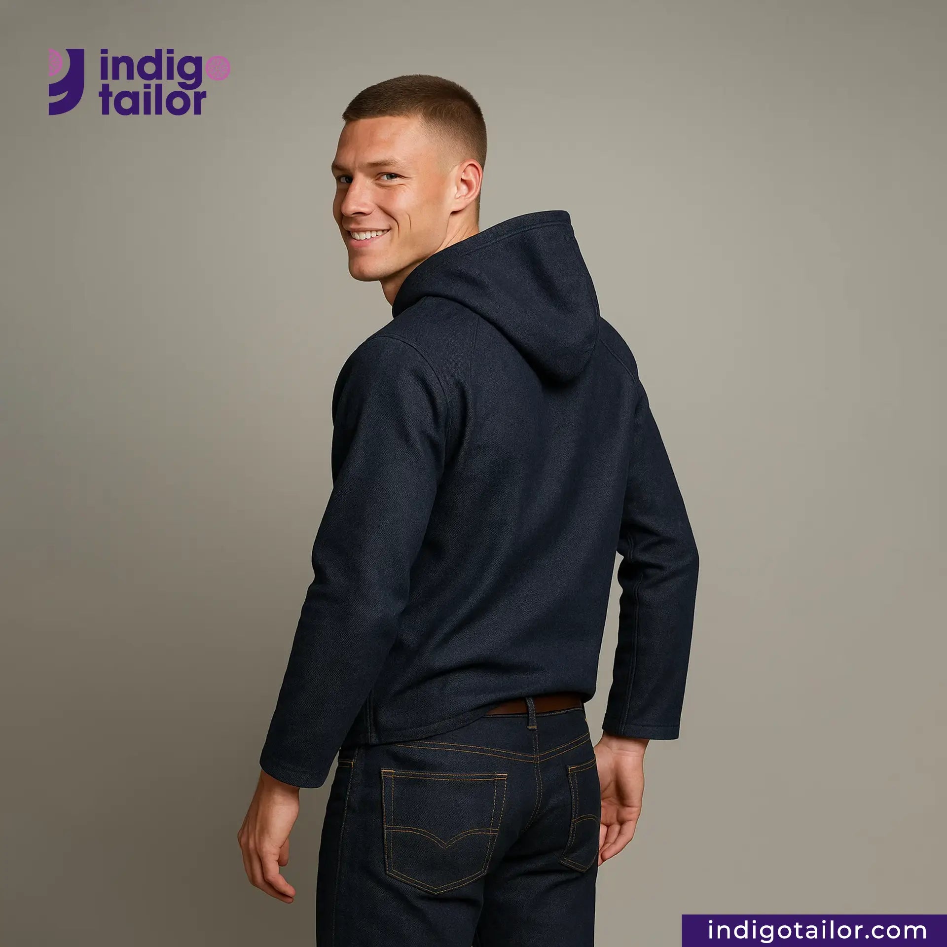 Man wearing a DENIM HOODIE and jeans with 'Indigo Tailor' logo and website on a gray background