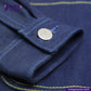 Close-up of a DOUBLE DIPPED TRIPLE PLEAT REPRO fabric with a button and yellow stitching, featuring the Indigotailor logo.