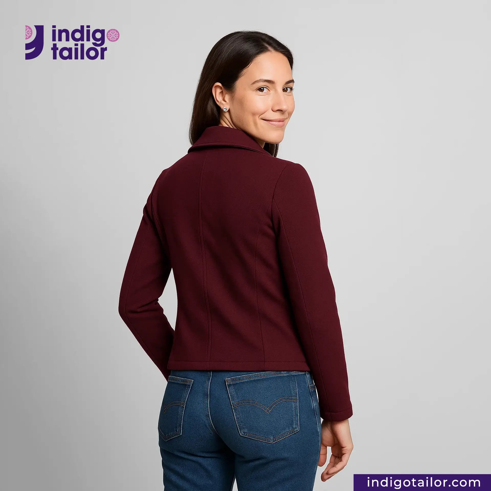 Woman wearing a Double Breasted Knit Peacoat (Burgundy) and blue jeans with 'Indigotailor' logo.