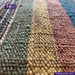Close-up of EARTH JACKET fabric with a brand logo in the corner