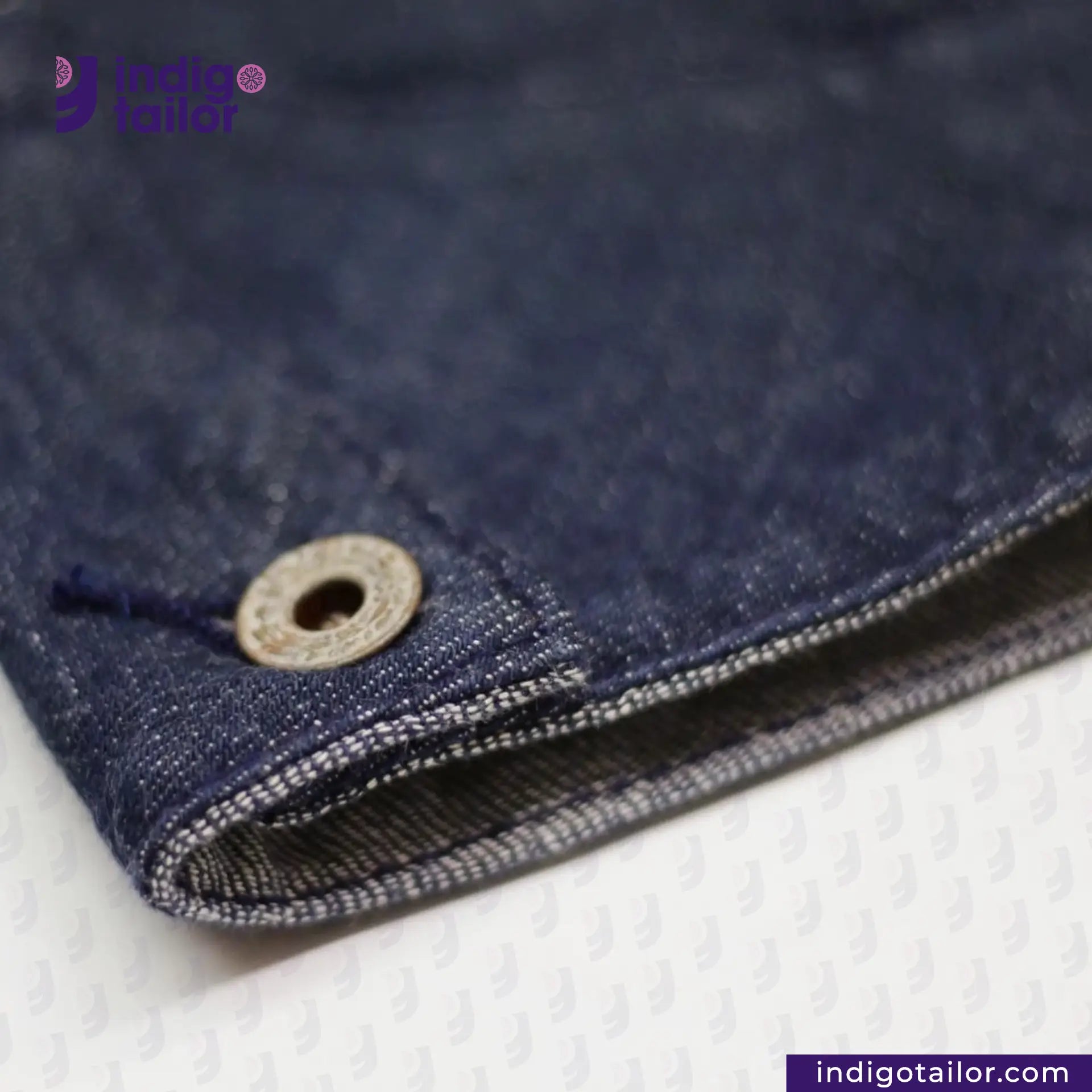 Close-up of FLIGHT JACKET with a button, featuring 'indigotailor' branding.