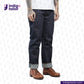 Person wearing dark blue jeans with rolled-up cuffs and brown shoes on a white background, with 'Indigo Tailor' logo.