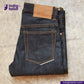 Folded pair of jeans with a brown patch on a textured surface, featuring the Indigotailor logo.