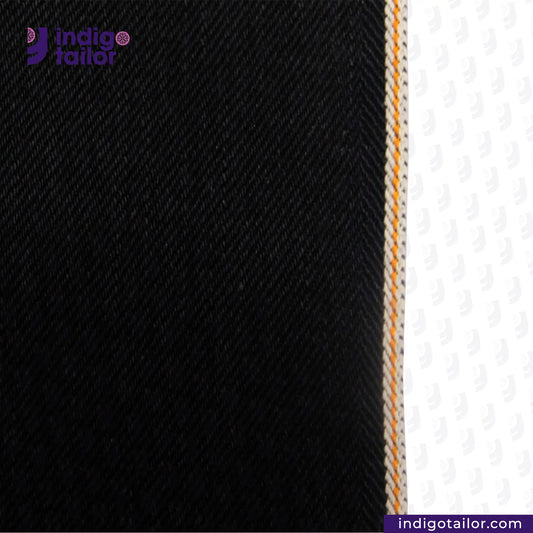 Close-up of HEAVY DOUBLE BLACK ORANGE SELVEDGE fabric with a visible brand logo on a white background