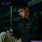 Man using a phone in a dark setting with 'Indigo Tailor' branding. wearing HEAVY DOUBLE BLACK ORANGE SELVEDGE ID jacket.