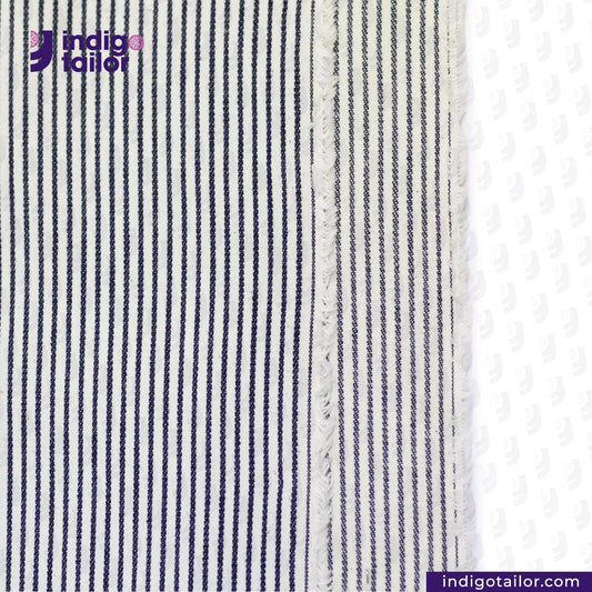 Close-up of HICKORY BLUEWHITE STRIPE fabric with 'indigotailor' logo and website.