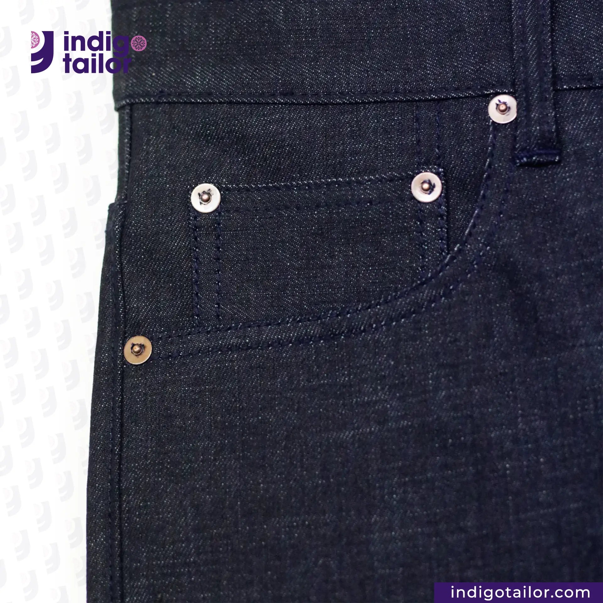 Close-up of INDIGO SAKURA DENIM denim jeans with button and stitching details, featuring 'Indigo Tailor' brand.