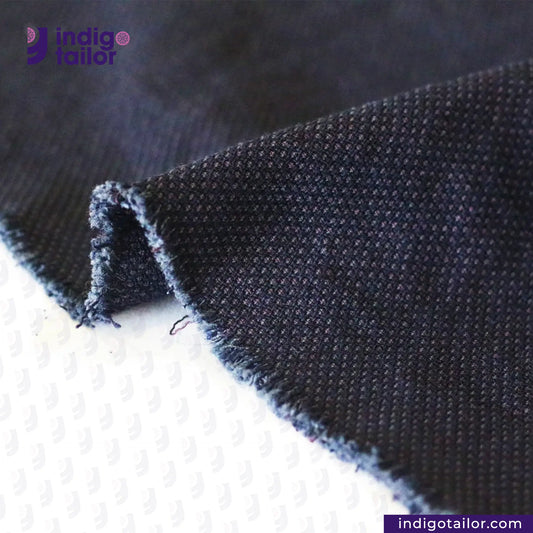 Close-up of INDIGO SASHIKO fabric with 'Indigo Tailor' branding.