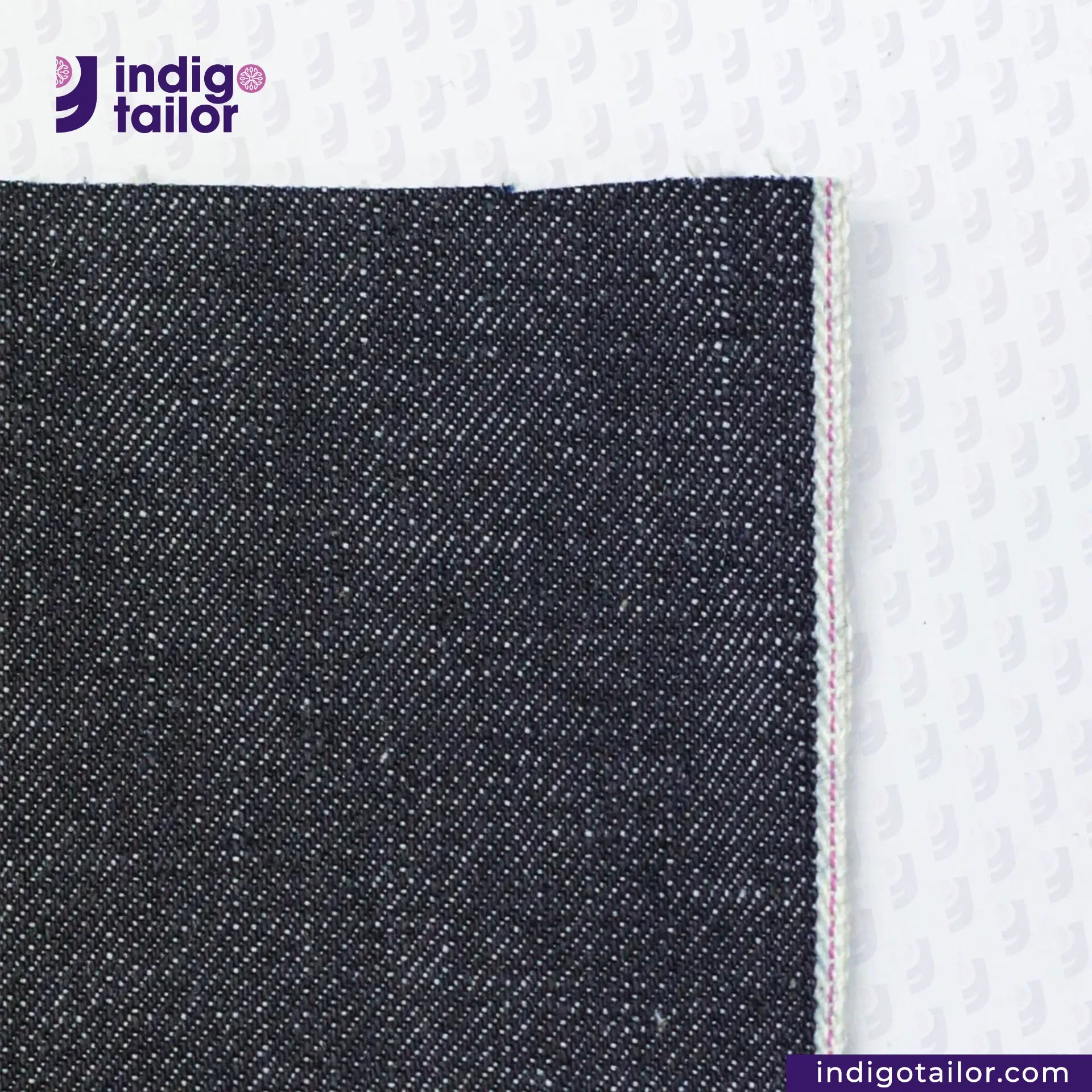 Close-up of KUROKI SLUBBY AND HEAVY DEEP INDIGO PINK SELVEDGE fabric with 'Indigo Tailor' logo and website URL.