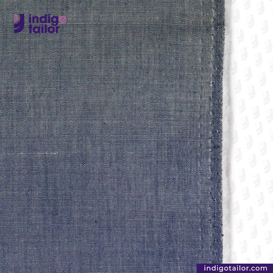 Close-up of LUST CHAMBRAY denim fabric with 'Indigotailor' logo and website URL.