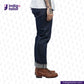 Person wearing MEDIUM BLUE DENIM LIVIDUS SELVEDGE jeans and brown shoes on a white background with 'Indigotailor' branding.