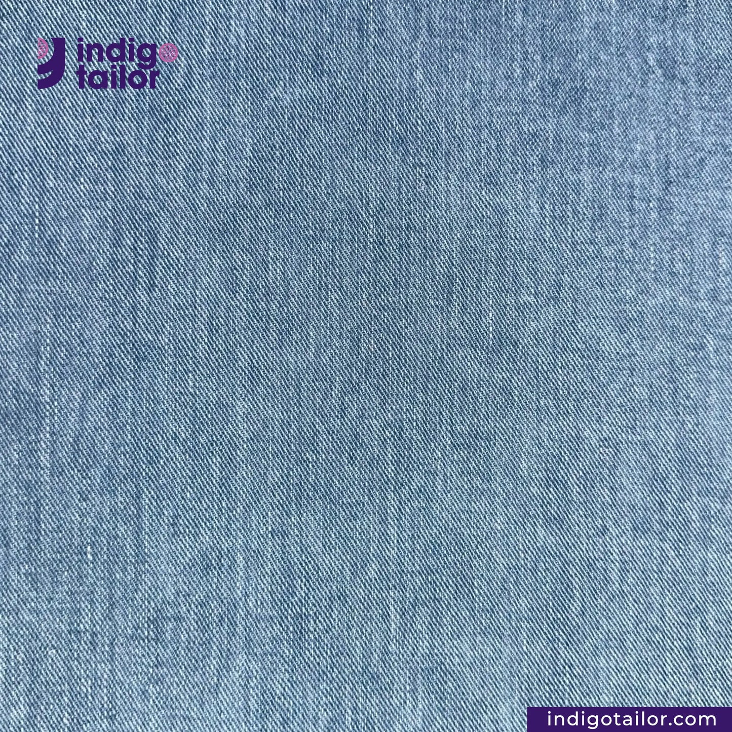 Close-up of NDL200 INDIGO x INDIGO HERRINGBONE DENIM fabric with 'Indigotailor' logo and website URL.