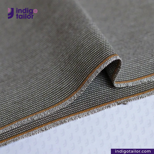 OLIVE WABASH SELVEDGE DENIM fabric with orange stitching on a textured surface, featuring the Indigotailor logo.