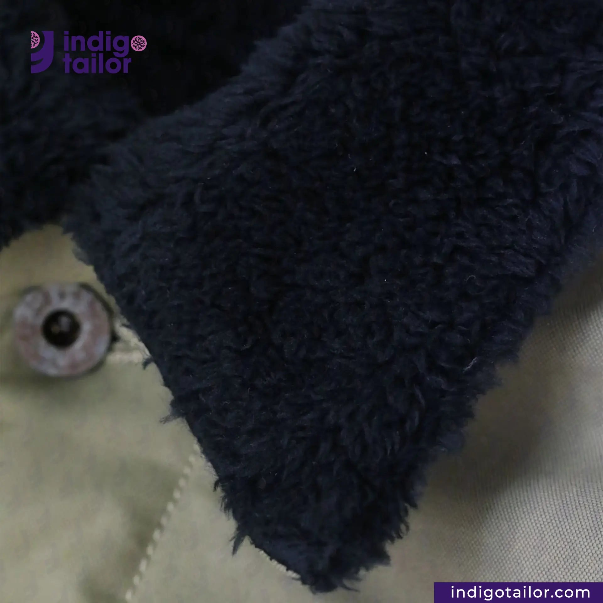 Close-up of SHERPA LINED WAXED CANVAS TRUCKER JACKET with 'indigotailor' branding.