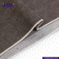Close-up of SLUBBY BROWN SELVEDGE DENIM fabric with 'Indigo Tailor' logo and website URL.
