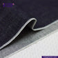 Close-up of SLUBBY INDIGO SELVEDGE DENIM fabric with visible stitching, brand 'Indigo Tailor' in the corner.