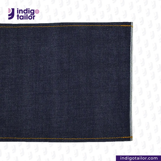 Close-up of SLUBBY INDIGO SELVEDGE DENIM fabric with 'Indigo Tailor' logo and website URL.