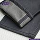 Close-up of SMOKE GREY DENIM jeans with a visible brand logo on a light background