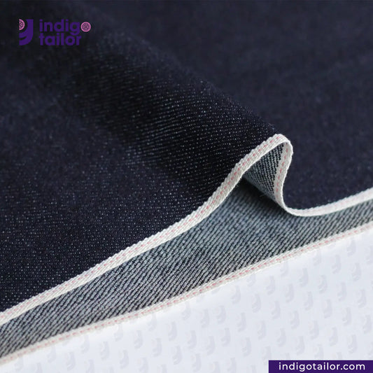 Close-up of STRETCHY SELVEDGE DEEP INDIGO PINK fabric with 'Indigotailor' branding.