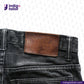 Close-up of SUPER BLACK DENIM jeans with a brown leather patch on a white background, featuring the 'Indigotailor' brand.