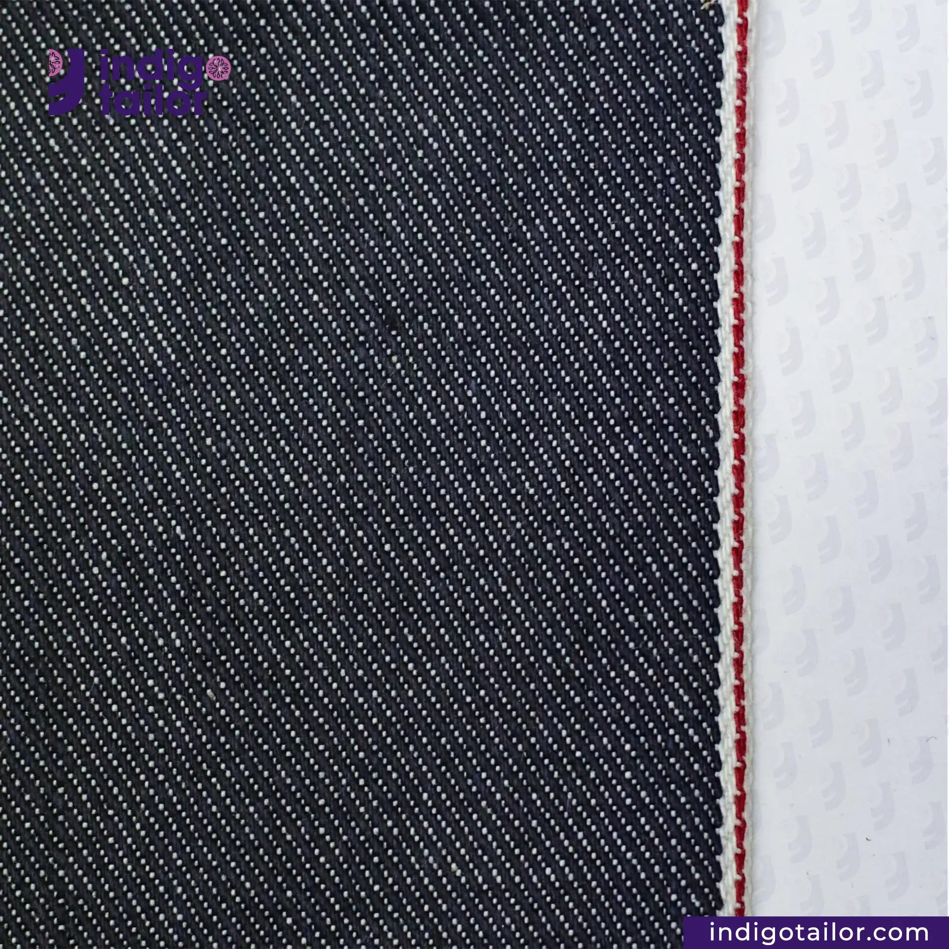 Close-up of SUPER SOFT FLUFFY SELVEDGE DENIM fabric with a white stripe and red stitching, featuring 'indigotailor' branding.