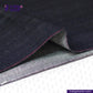 Close-up of TROPIC CITY DENIM fabric with visible stitching, featuring the Indigo Tailor logo.