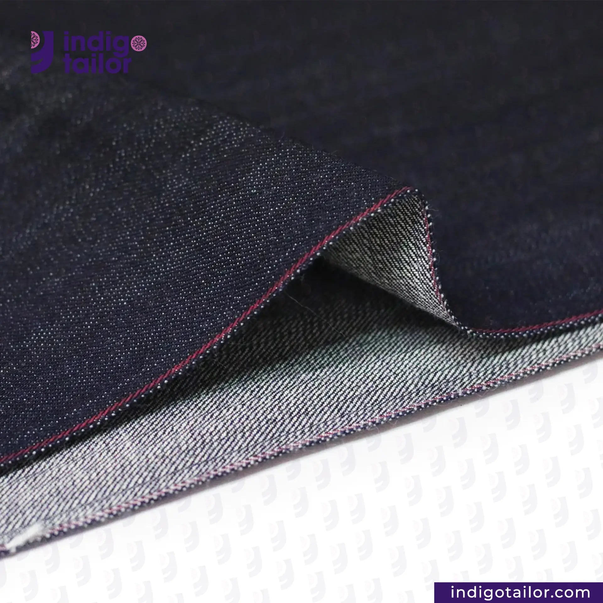 Close-up of TROPIC CITY DENIM fabric with visible stitching, featuring the Indigo Tailor logo.