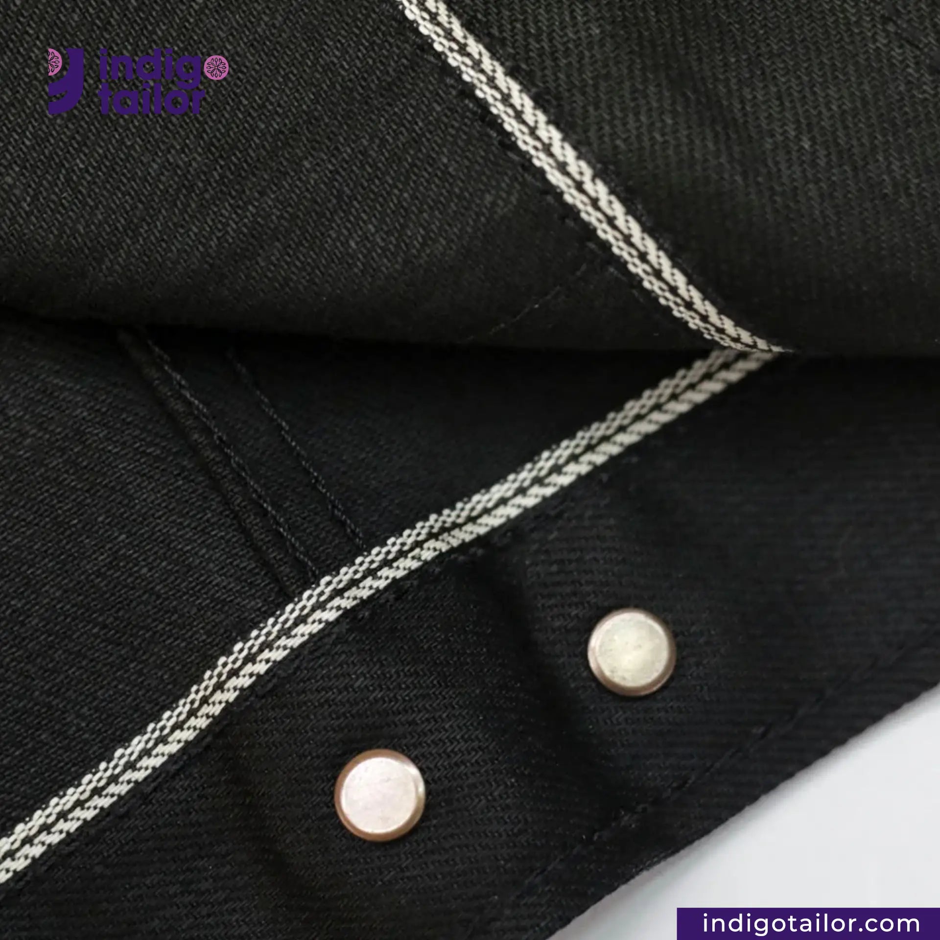 Close-up of TYPE III DOUBLE BLACK TRUCKER JACKET with white stitching and buttons, featuring Indigo Tailor logo.