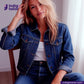 Woman wearing a VINTAGE BLUE SELVEDGE DENIM jacket sitting on a chair with 'indigotailor' branding.