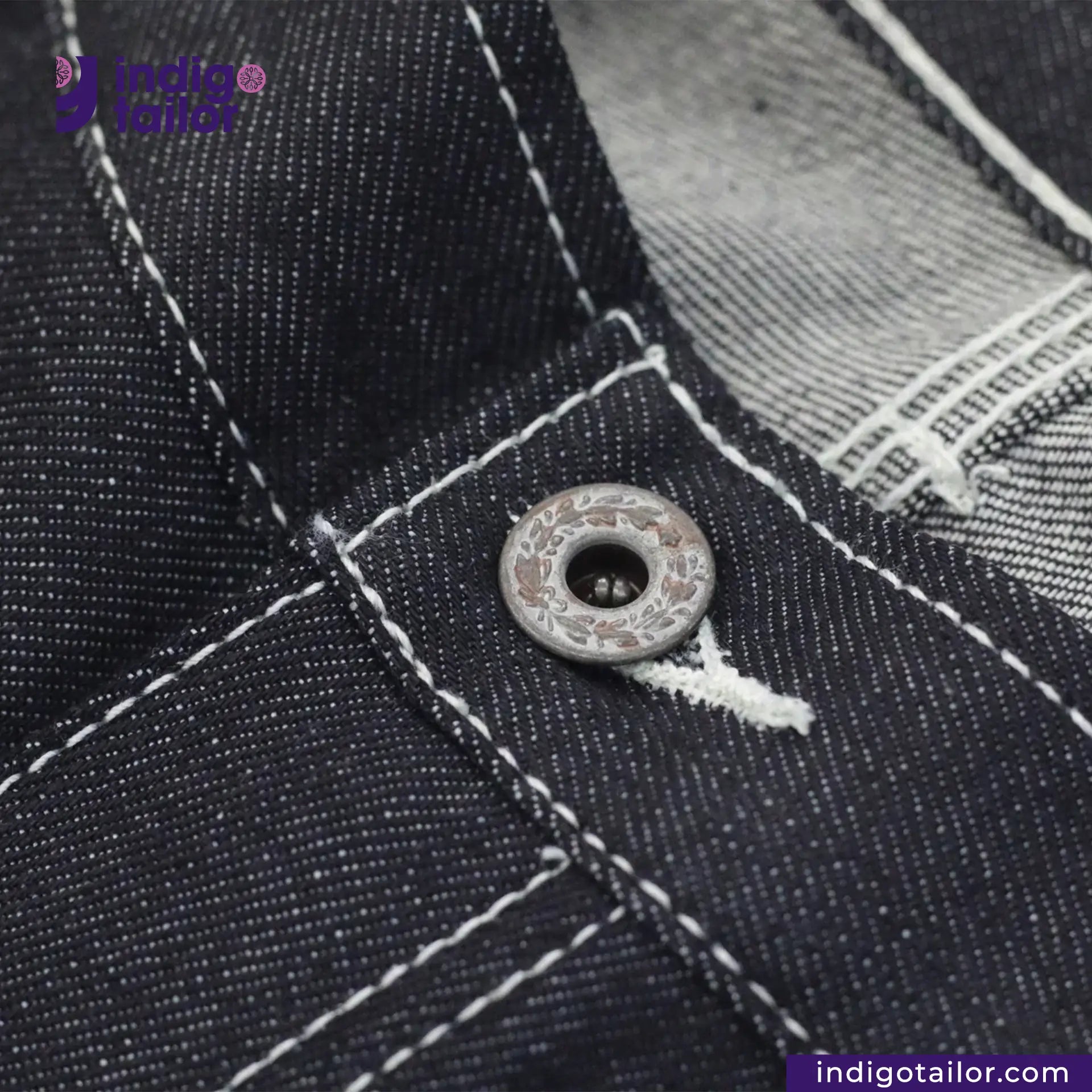 Close-up of a button on Vintage Workwear Jeans with 'Indigo Tailor' branding.