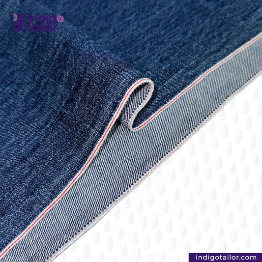 Close-up of WASHED VINTAGE SLUB SELVEDGE DENIM fabric with a visible brand logo on a white background