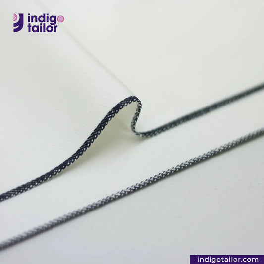 Close-up of WHITE DENIM NAVY SELVEDGE thread on a white background with 'indigotailor' branding.